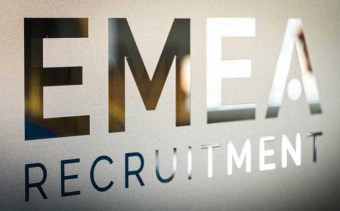 Photograph of the EMEA Recruitment logo embossed on the wall of the EMEA Recruitment office